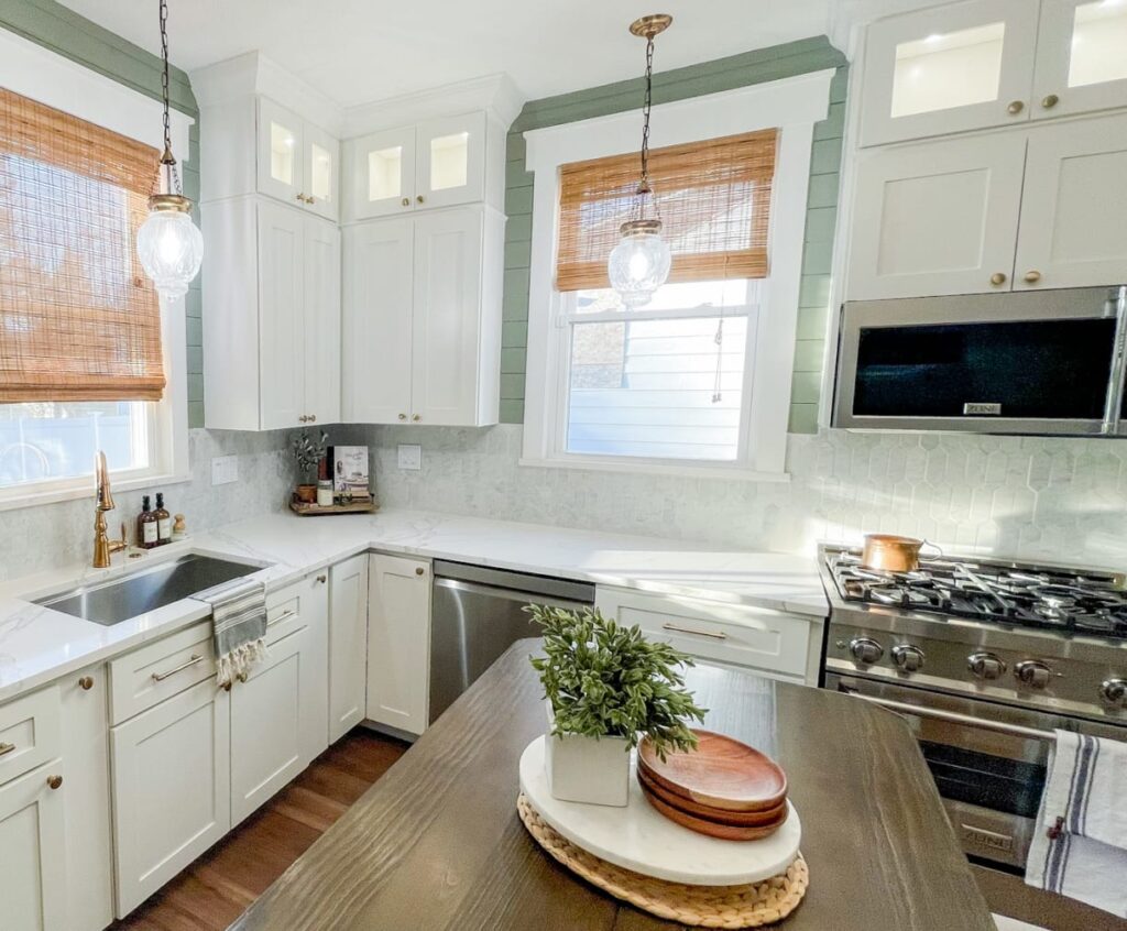 A small kitchen with white cabinets and a butcher-block island.