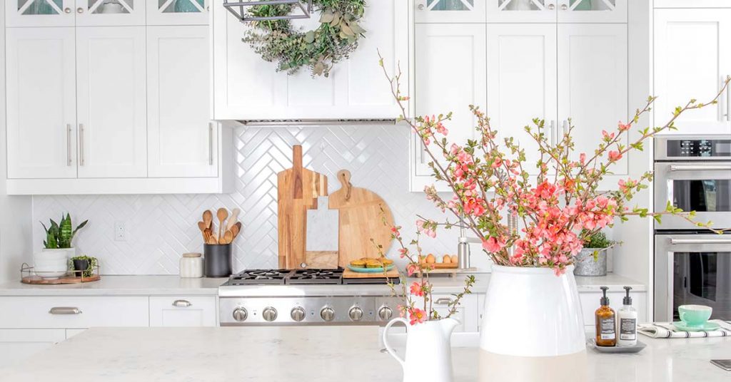 White kitchen with shaker cabinets decorated with flowers.