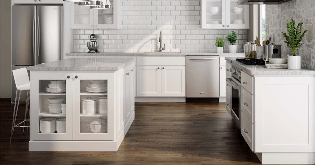 White shaker cabinets in a kitchen with dark wood floors.