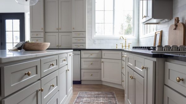 Large kitchen with bright light Sand Shaker cabinets, gold hardware, and countertop cabinets.