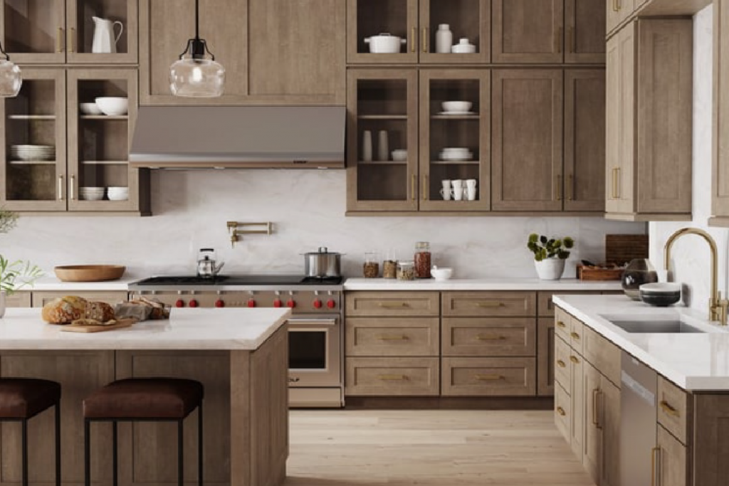 Large kitchen in mid-tone wood with marble backsplash and white quartz countertops with gold handles and fixture.