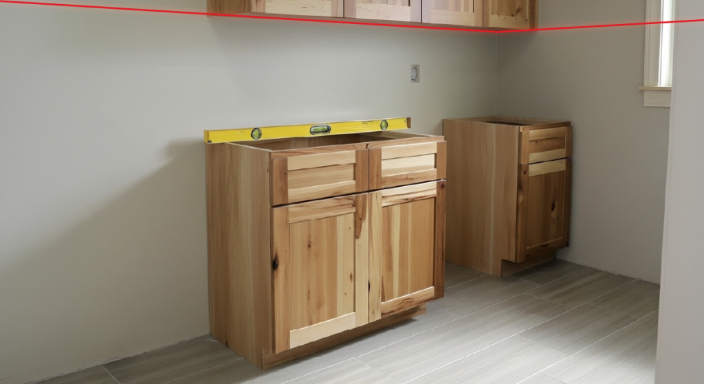 Kitchen under construction with level on top of the cabinet.